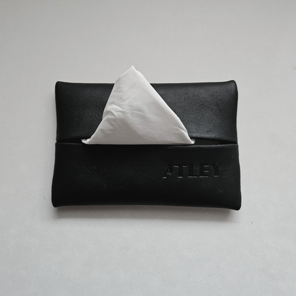 Black leather tissue holder with a white tissues travel pouch