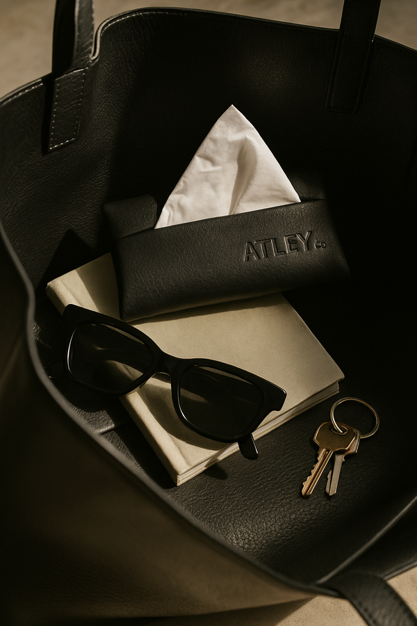 Black handbag with sunglasses, keys, and a wallet labeled 'ATLEY'.